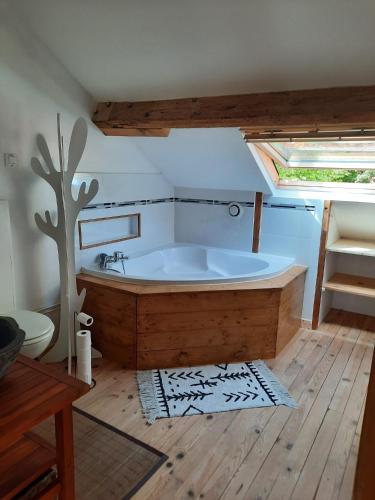 une grande baignoire dans une salle de bain avec une fenêtre dans l'établissement La Bastide, à Saint-Vincent-de-Tyrosse