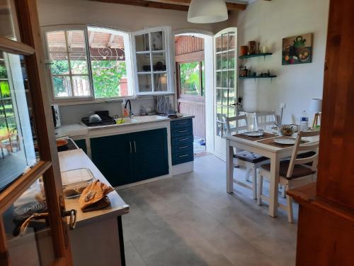 a kitchen with blue cabinets and a table in it at La Bastide in Saint-Vincent-de-Tyrosse