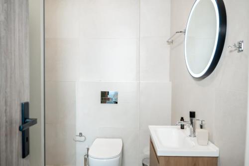 a bathroom with a toilet and a sink and a mirror at Villa Scorpios View in Nydri