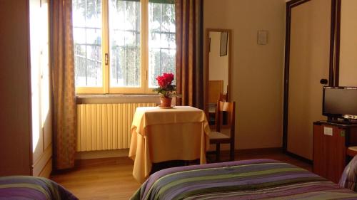 een kamer met een tafel met een vaas met bloemen erop bij Affittacamere Giudici in Lentate sul Seveso