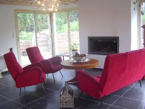 salon z czerwonymi krzesłami, stołem i kominkiem w obiekcie L'Atelier w mieście Wissant