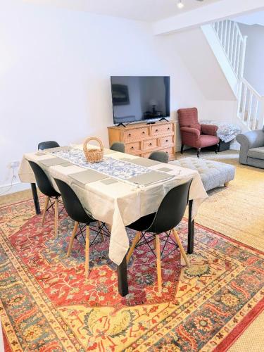 a living room with a table and chairs on a rug at The Old Post Office - Central Helmsley with Parking in Helmsley