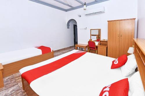 a bedroom with a white bed and a desk and a desk at OYO 139 Al Ghadeer Hotel Apartments in Barka