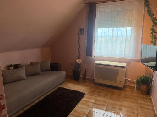 a living room with a couch and a window at Angyalszív Apartman in Zalakaros