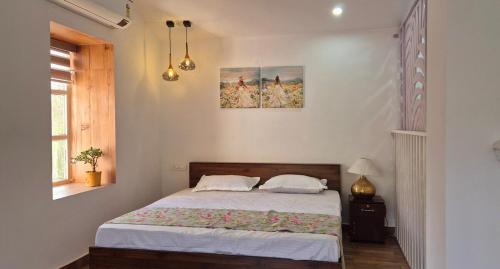 a bedroom with a bed with white sheets at Buraans in Dehradun