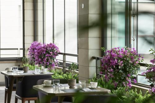 two tables and chairs with purple flowers on a balcony at September Hotel Thessaloniki in Thessaloniki
