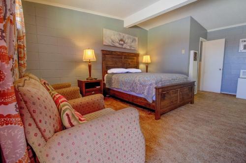 a bedroom with a bed and two chairs at Wheeler Inn Texas, US - 83 By OYO in Wheeler