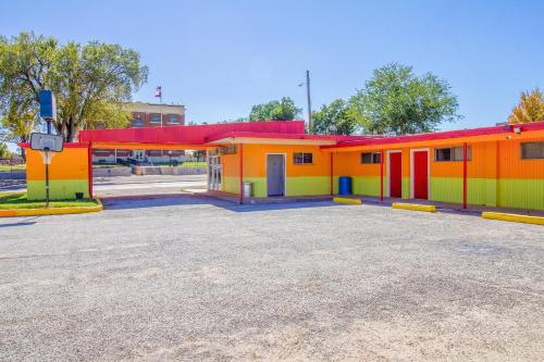 a row of colorful buildings in a parking lot at Wheeler Inn Texas, US - 83 By OYO in Wheeler