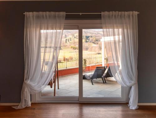 a sliding glass door with white curtains in a room at Bes Hotel Terme a Palazzago in Palazzago