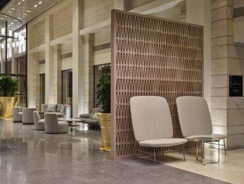 a lobby with white chairs in a building at September Hotel Thessaloniki in Thessaloniki