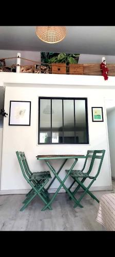 un bureau et deux chaises vertes dans une pièce dans l'établissement Ty'ca house, à Velleron