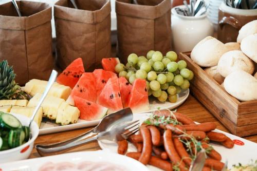 a table topped with plates of food with fruit and vegetables at Hotel Norden in Haderslev