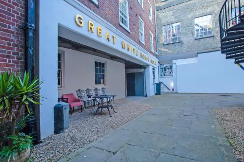 a building with chairs and tables outside of it at Great White Horse Hotel in Ipswich