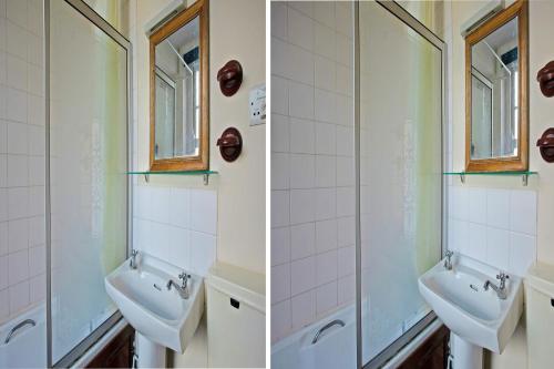 a bathroom with two sinks and two mirrors at Great White Horse Hotel in Ipswich