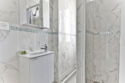 une salle de bain blanche avec un lavabo et une douche dans l'établissement Peaceful and modern apartment - II, à Gagny