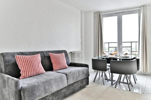 un salon avec un canapé et une table dans l'établissement Peaceful and modern apartment - II, à Gagny