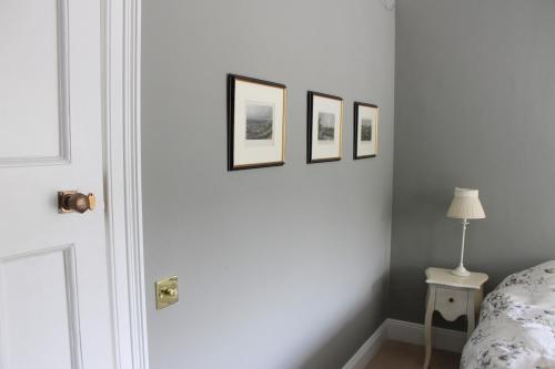 a bedroom with three framed pictures on the wall at Country home with a Pub, Restaurant & Brewery onsite ! in Rathcoffey