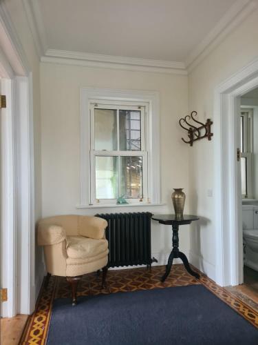 a room with a chair and a table and a window at Country home with a Pub, Restaurant & Brewery onsite ! in Rathcoffey