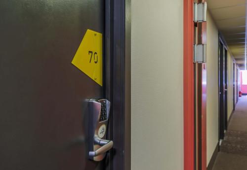 a yellow sign on the door of a hallway at B&B HOTEL Freyming-Merlebach in Freyming