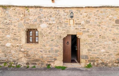 a stone building with a door and a window at Deluca Stone House in Gennadi