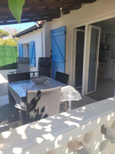 un patio avec une table et des chaises sur un porche dans l'établissement Sunny Cottage, à Fréjus