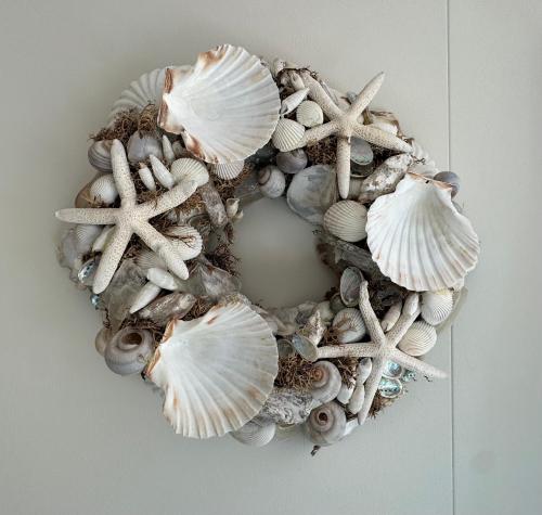 a wreath of shells and starfish on a table at ThuizInOuddorp Parel no 30 & Oester no 29 Verkoeling aan Zee in Ouddorp