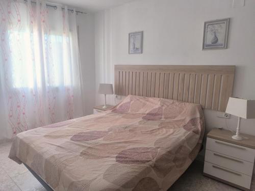 a bedroom with a bed and two lamps and a window at Sombrero in Miami Platja