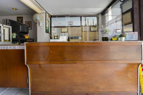 a wooden bar in a restaurant with a counter at Hotel O Anugerah in Jember