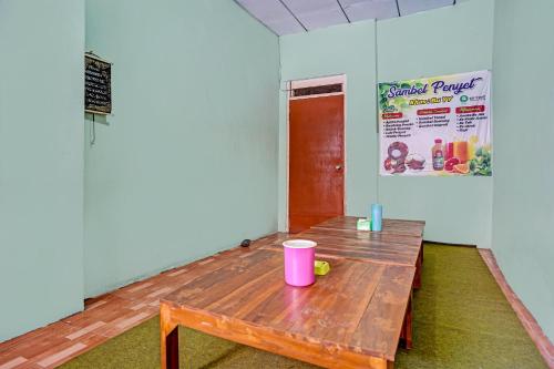 a room with a wooden table with a pink cup on it at SPOT ON 91716 Kost Yy Syariah in Mojokerto