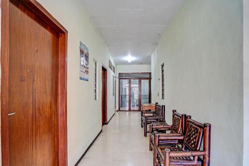 a row of chairs in a hallway with a door at SPOT ON 91716 Kost Yy Syariah in Mojokerto