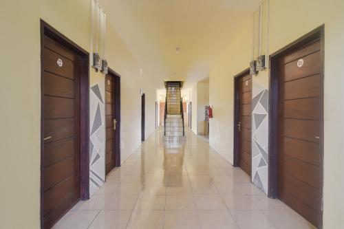 a hallway with two sets of doors and tile floors at Hotel O Priska Kost Dan Homestay in Manado