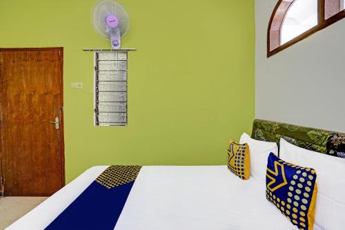 a bedroom with a bed with a fan on the wall at SPOT ON 91716 Kost Yy Syariah in Mojokerto