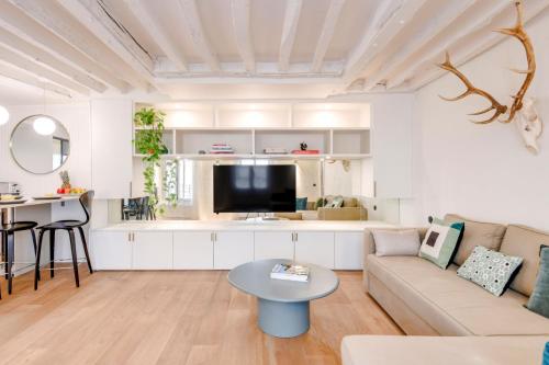 un salon avec un canapé et une table dans l'établissement BnBNova - 2BR - La Seine & Saint Germain, à Paris