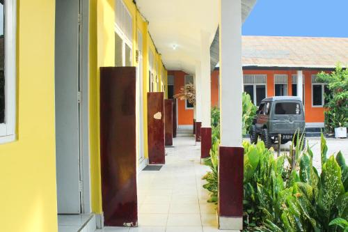 an empty hallway of a building with a car parked in it at Hotel O Wisma Harapan Baik in Kupang
