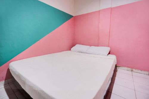 a bed in a room with a colorful wall at Hotel O Solo Baru Homestay Syariah in Jodoh