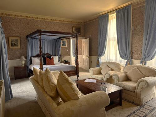 a living room with a bed and a couch and chairs at Grafton Manor Hotel in Bromsgrove