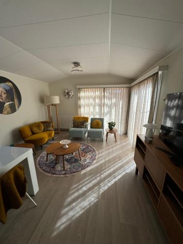 a living room with a couch and a table at ThuizInOuddorp Parel no 30 & Oester no 29 Verkoeling aan Zee in Ouddorp