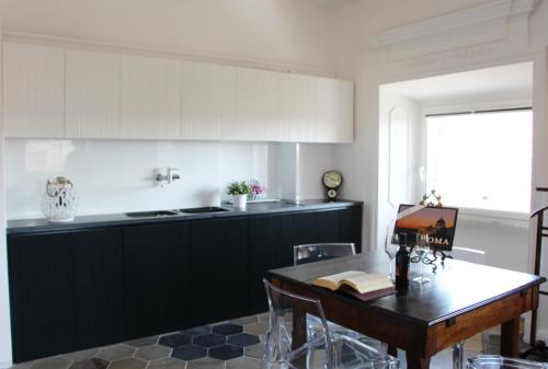 ローマにあるLa Rosa del Vaticano Luxury Apartmentのテーブル付きのキッチン、白黒のキッチンが備わります。
