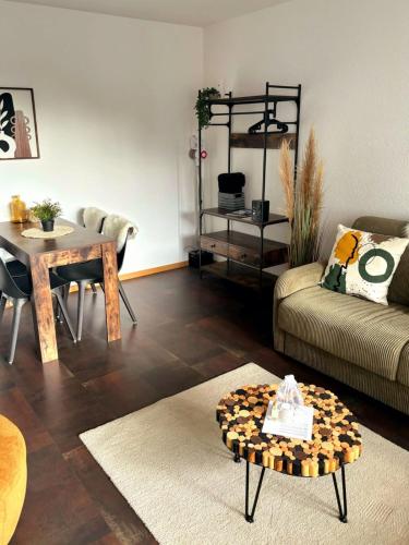 a living room with a couch and a table at Studio au Cœur des Sommets in Crans-Montana