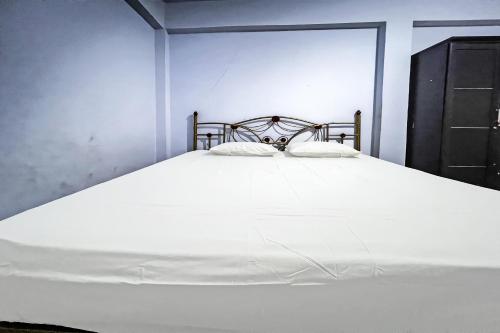 a large white bed with two pillows on it at Hotel O Surya HotelNearTaman Anggrek Pkk Watansoppeng in Watansopeng