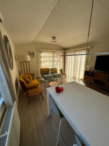 a living room with a couch and a table at ThuizInOuddorp Parel no 30 & Oester no 29 Verkoeling aan Zee in Ouddorp