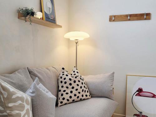 a living room with a couch with pillows and a lamp at Adellia Pension in Gyeongju