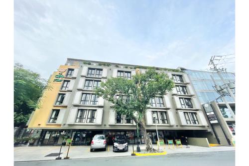 a large white building with cars parked in front of it at CEO Flats in Manila