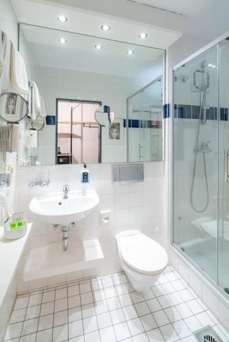 a bathroom with a toilet and a sink and a shower at Hotel Jean-Paul in Schwarzenbach an der Saale