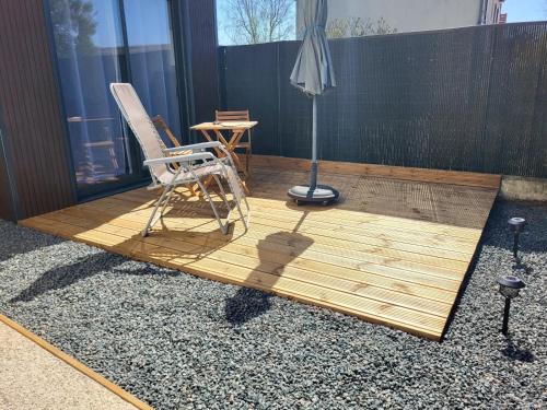a wooden deck with a chair and a lamp at Chez LilYves in Bouray-sur-Juine