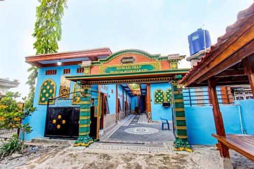 a blue building with a sign on it at SPOT ON 91811 Rumah Inap Bunda Nurhayati in Praya