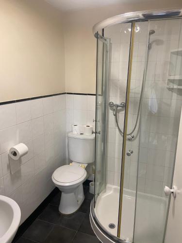 a bathroom with a toilet and a glass shower at OYO Gran Canaria Hotel in Folkestone