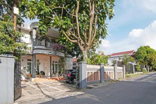 a car parked in front of a house with a fence at Hotel O Yoezef Homestay Syariah in Pekanbaru