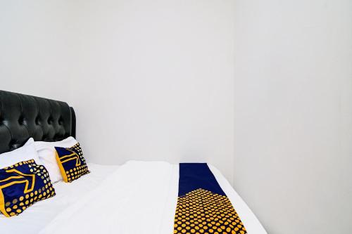 a bed with two ties sitting on top of it at Hotel O Homestay Dinda Syariah Near Masjid Al Amin in Parit