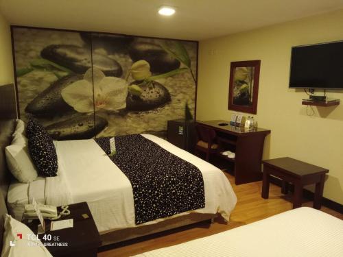 a hotel room with a bed and a painting on the wall at Loft Hotel in Pasto